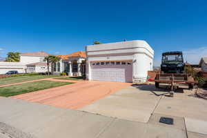 View of front of property with driveway, stucco siding, and an attached garage