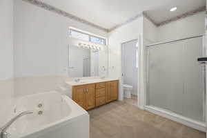 Full bath with double vanity, a tub with jets, a shower stall, and light colored carpet
