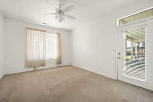 Carpeted empty room featuring a ceiling fan and baseboards
