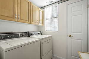Laundry room with washer and clothes dryer and cabinet space