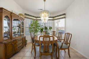 Dining room featuring plenty of natural light, light tile patterned floors, and suspended lighting