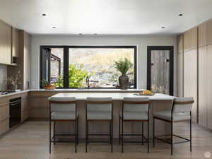 Kitchen featuring modern cabinets, a kitchen breakfast bar, and light wood-type flooring
