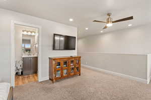 Living area with light carpet, a ceiling fan, and recessed lighting