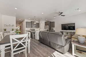 Living area with wood finished floors, ceiling fan, and recessed lighting