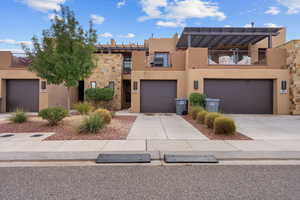 View of front of home with stucco siding, concrete driveway, a garage, and stone siding