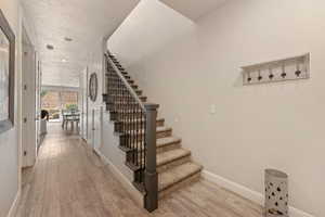 Stairway featuring wood finished floors