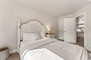 Bedroom with baseboards and dark colored carpet
