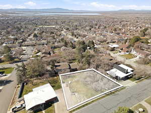Aerial perspective of suburban area with a mountainous background and property parcel outlined