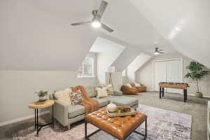Upstairs bonus room featuring light carpet, ceiling fan, and vaulted ceiling