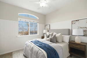 Second main floor bedroom featuring wainscoting and a ceiling fan