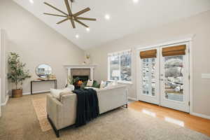 Family room with lofted ceiling, ceiling fan, a fireplace, recessed lighting, and French doors that lead to the backyard patio