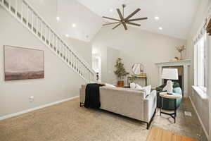 Family room featuring ceiling fan, light colored carpet, lofted ceiling, a fireplace, and recessed lighting