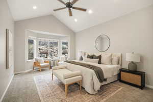 Main level Master bedroom with light carpet, a ceiling fan, a high ceiling, bay windows and recessed lighting