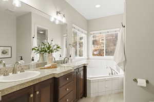 Master bathroom featuring a garden tub, double vanity, recessed lighting, and a walk in shower