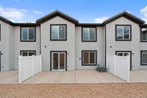 Rear view of house featuring stucco siding, a patio area, and a tiled roof