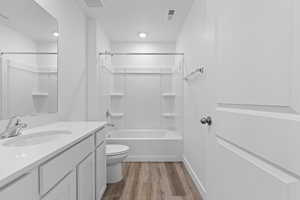 Bathroom featuring vanity, light wood-style flooring, and shower / bath combination
