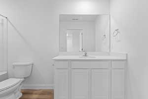 Full bath featuring vanity, dark wood-type flooring, and bathing tub / shower combination