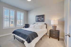 Bedroom featuring baseboards and light carpet