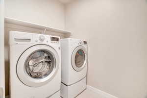 Laundry area featuring washer and dryer and baseboards