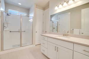 Full bath with vanity, a stall shower, and light tile patterned floors