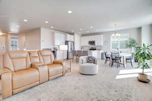 Living area featuring light wood-style flooring and suspended lighting
