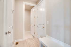 Mudroom featuring light wood-style flooring and baseboards