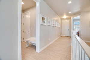 Hall featuring light wood-type flooring and recessed lighting