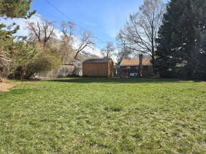 Fenced yard featuring a storage unit