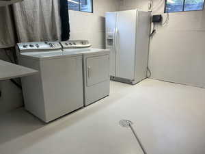 Laundry area featuring concrete floors and washing machine and dryer