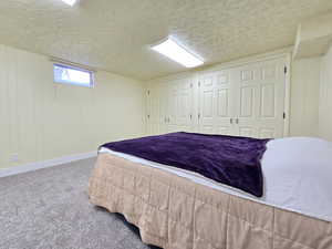 Carpeted bedroom with wooden walls and a textured ceiling