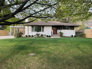Ranch-style house with a carport and brick siding