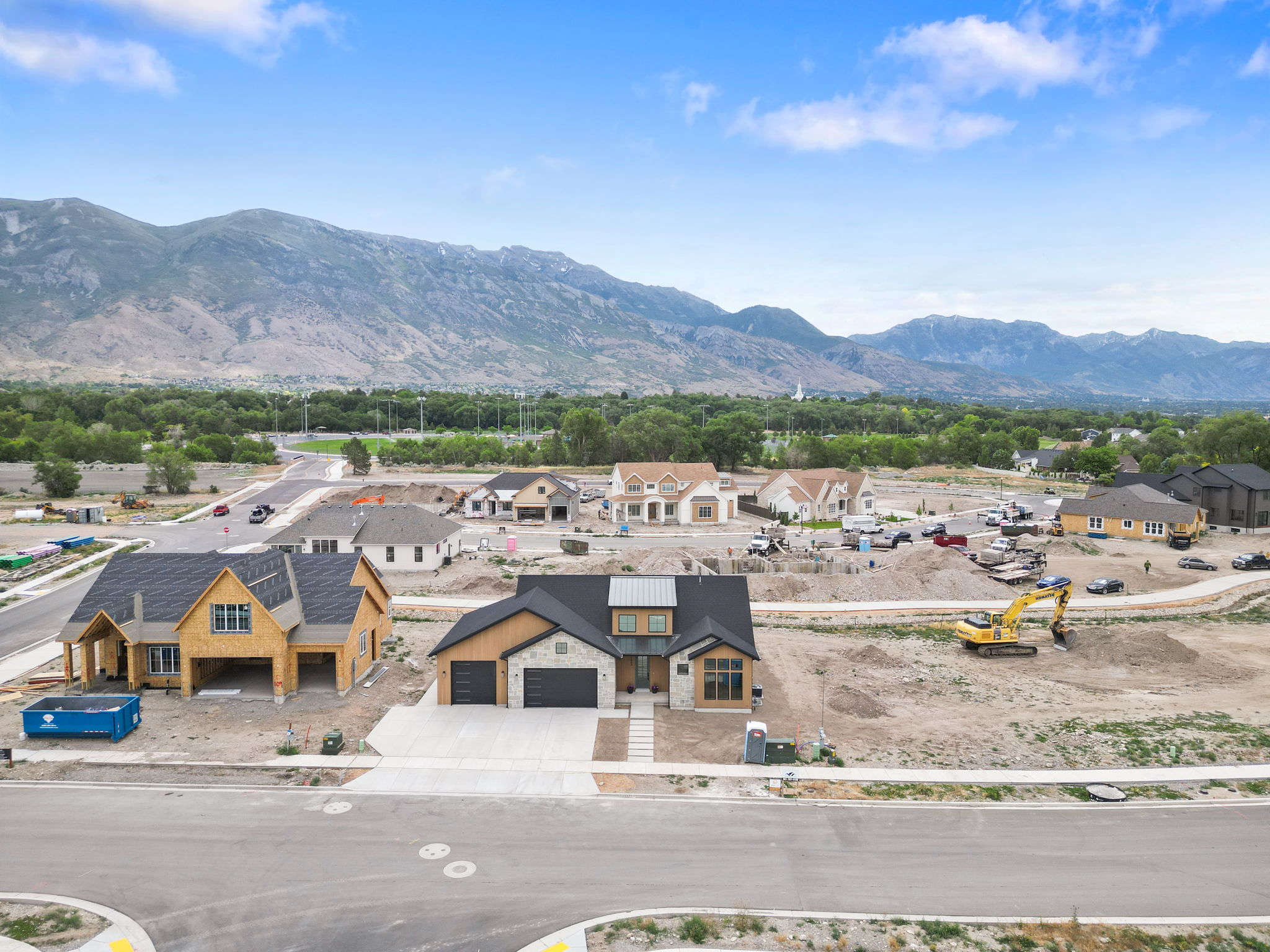 Newly constructed residence featuring a contemporary exterior with stone accents, a two-car garage, and a concrete driveway