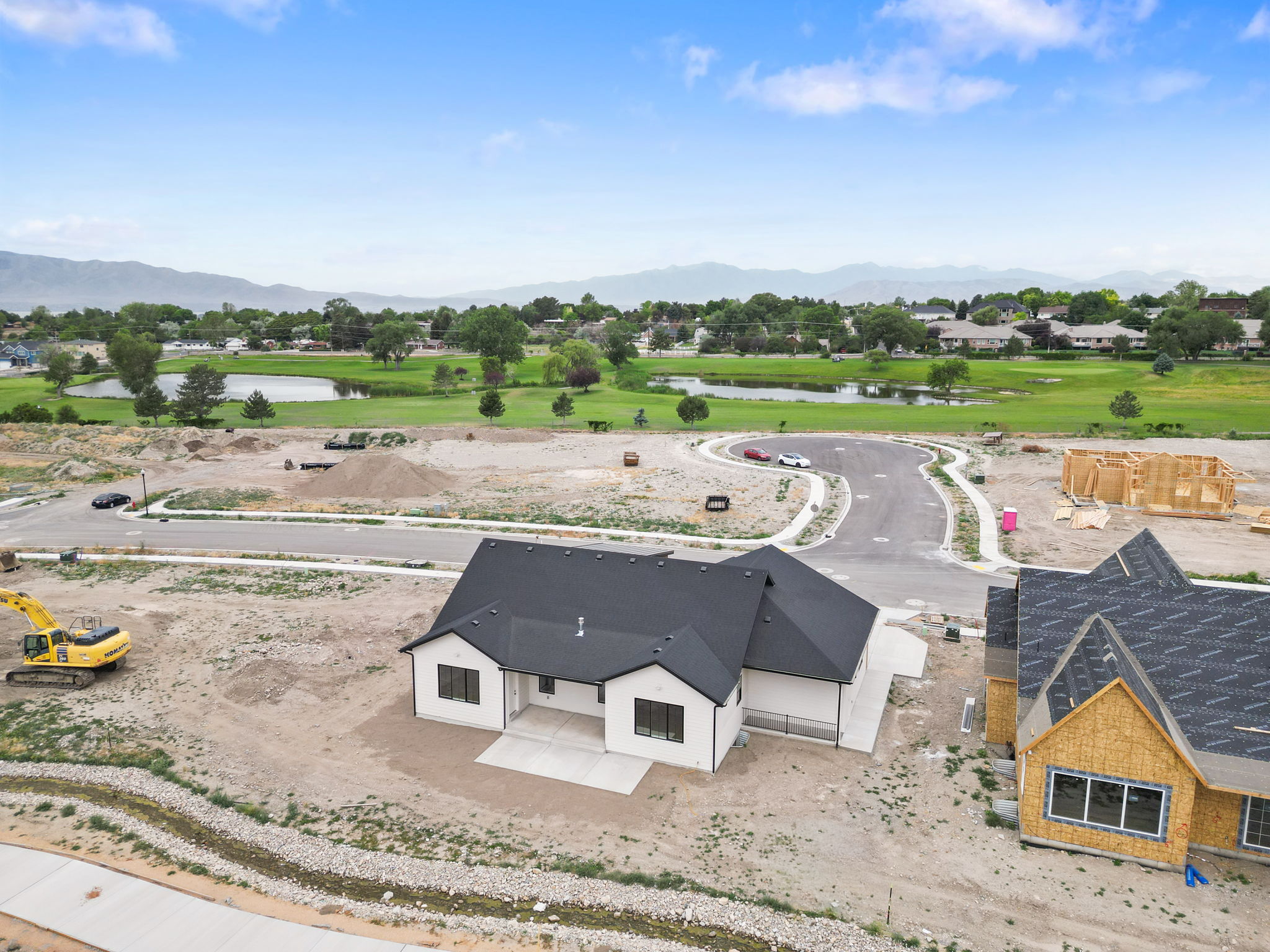 New construction home featuring a white exterior, dark roof, and black-framed windows