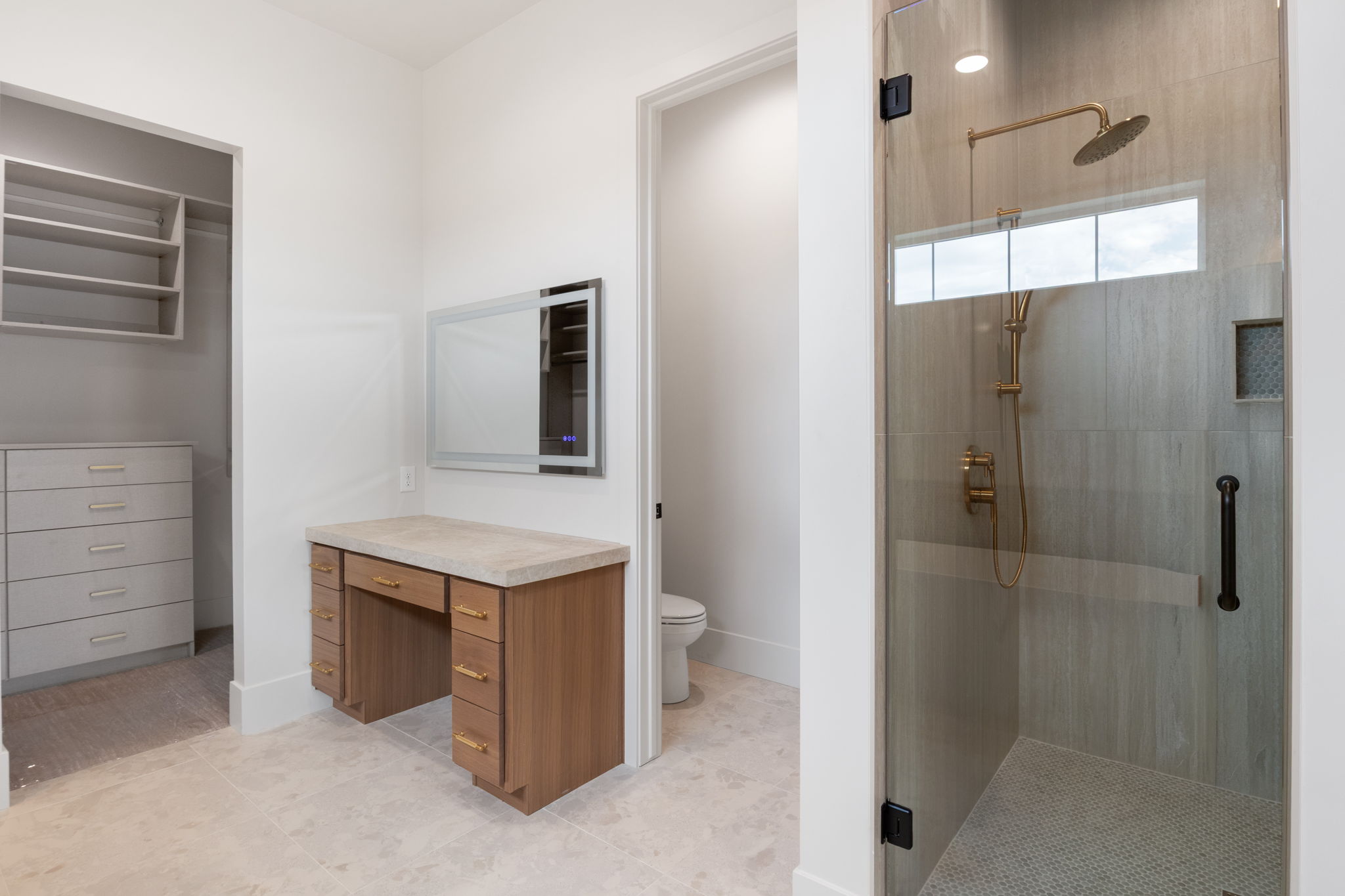 Spacious bathroom with a walk-in shower featuring a glass enclosure and a rain showerhead