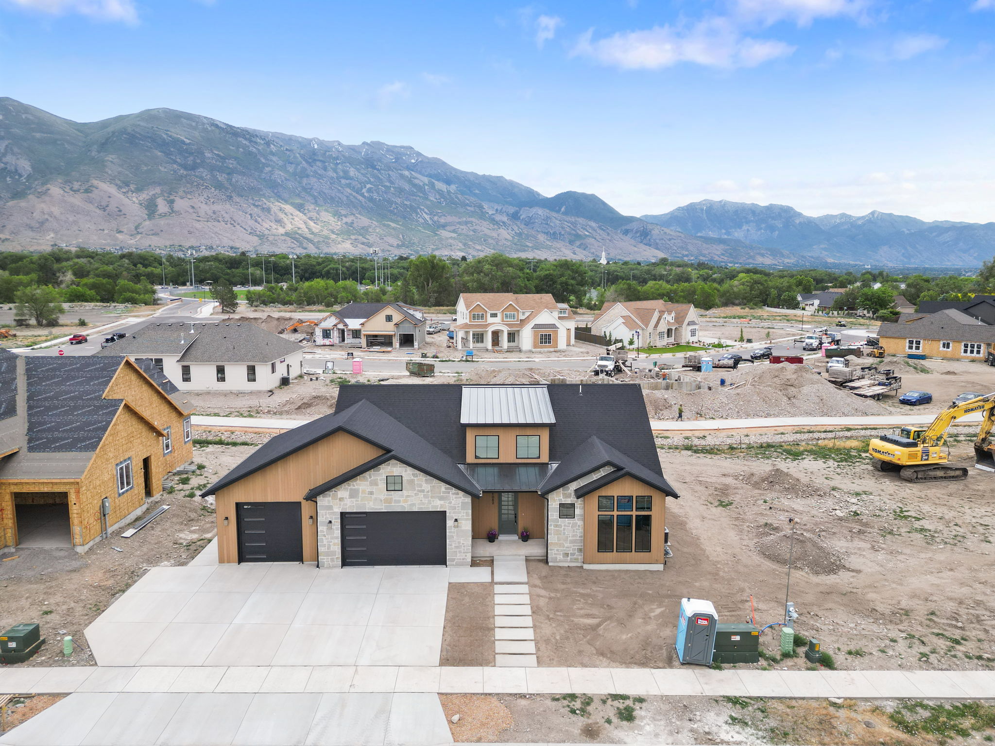 Modern construction featuring a prominent dark roofline and light-colored stone accents