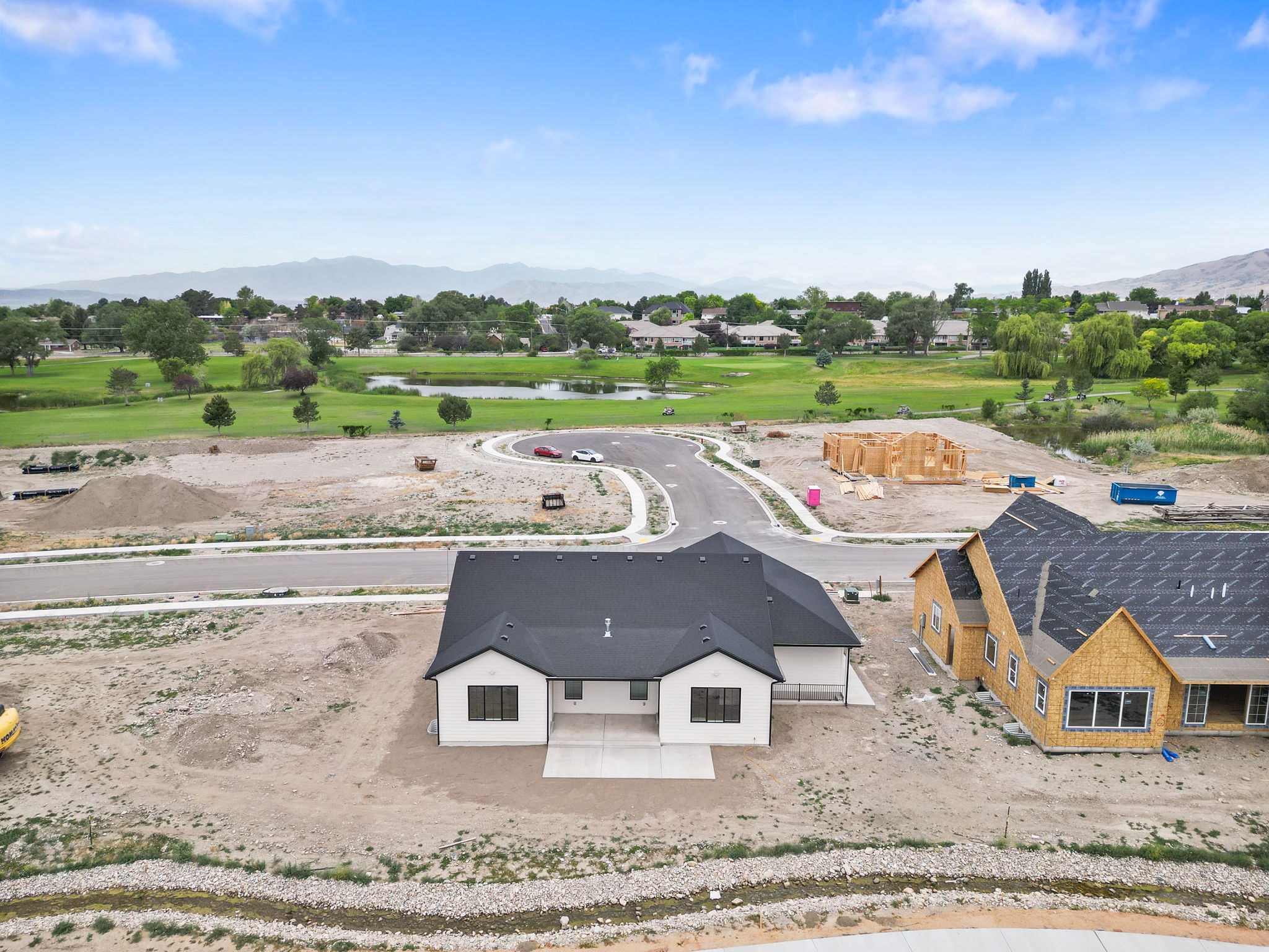 Modern ranch-style residence featuring a dark shingle roof, white siding, and a concrete patio