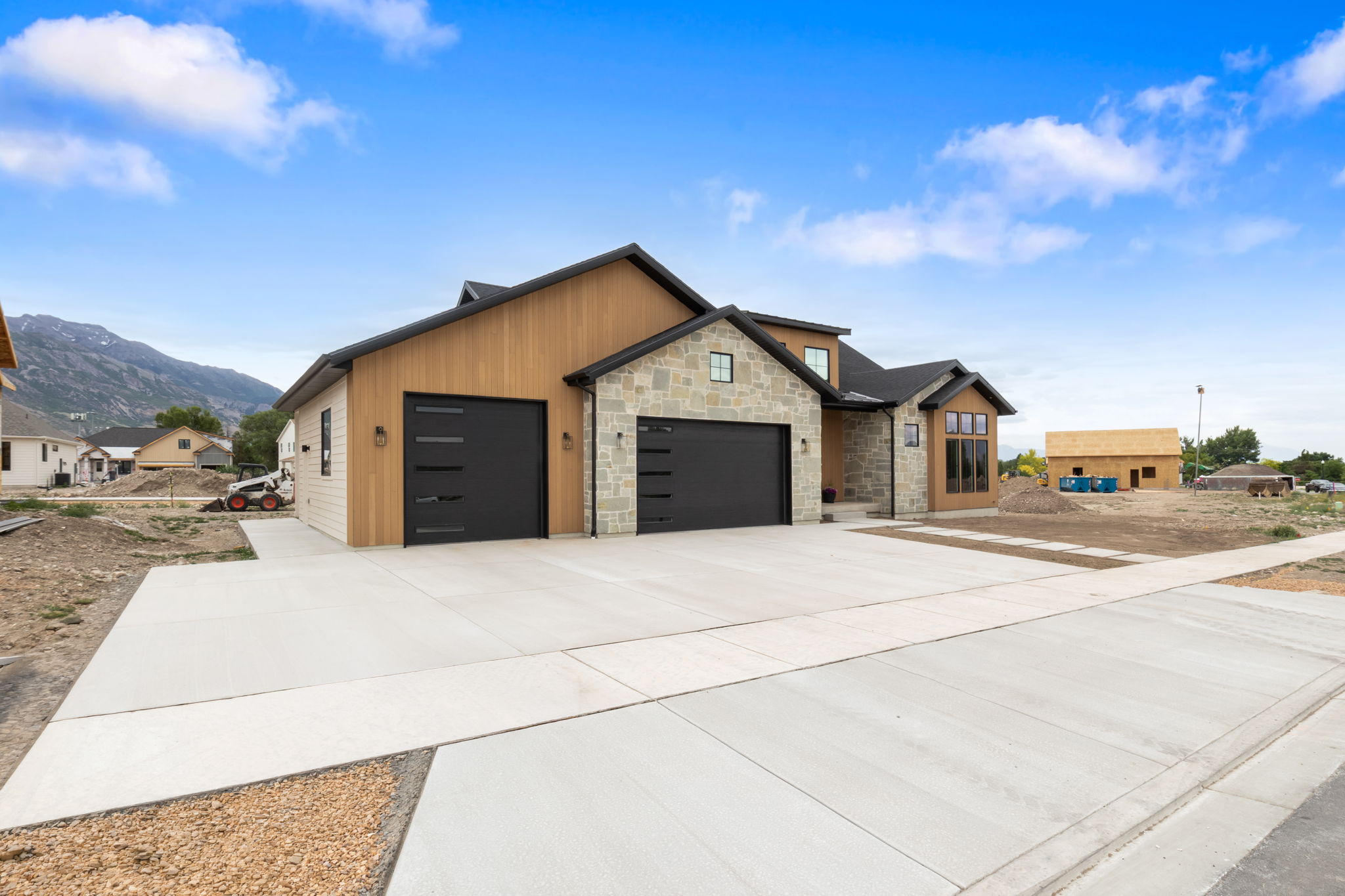 Contemporary exterior featuring stacked stone and vertical wood siding