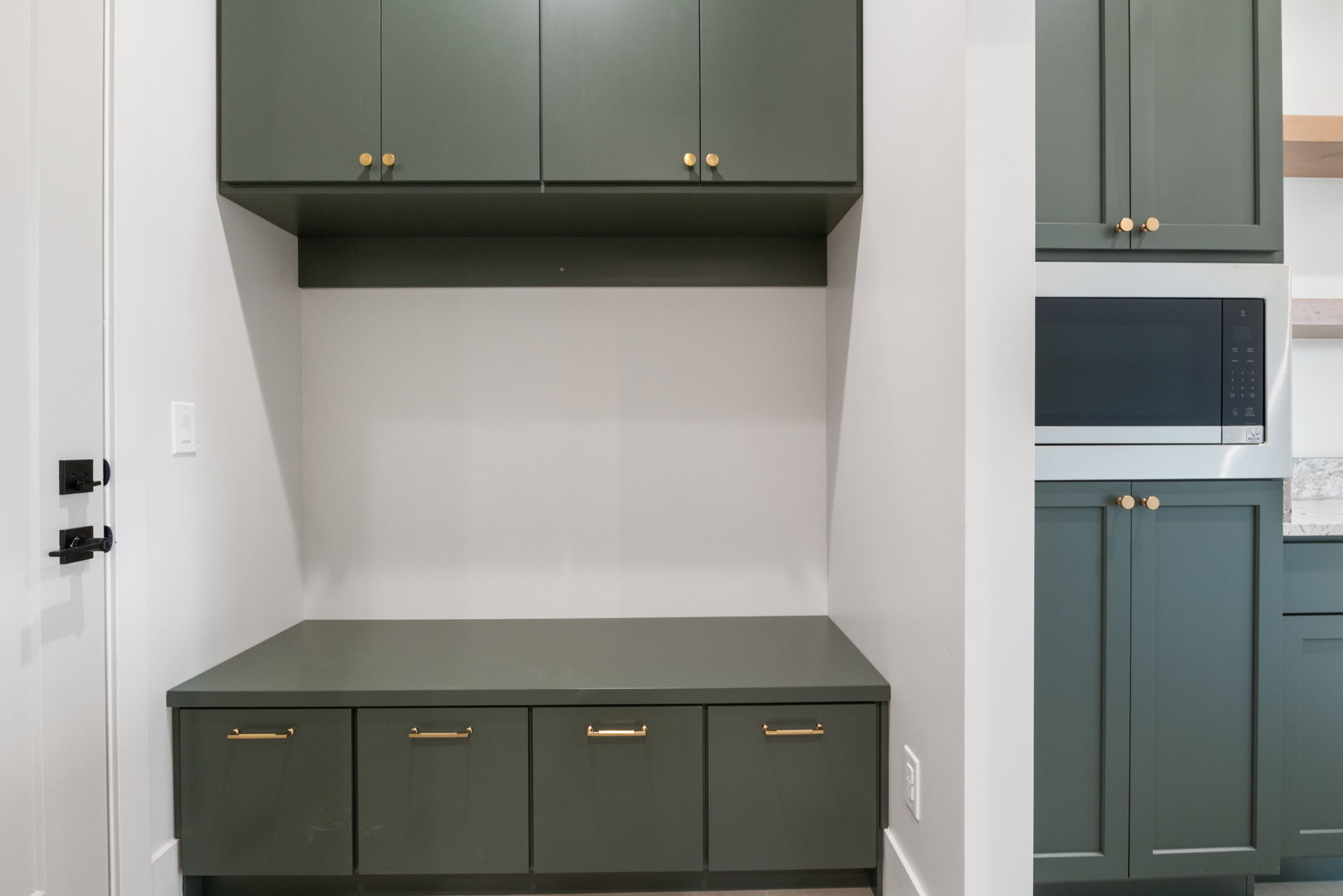 Built-in mudroom bench featuring three drawers and an open cubby, complemented by two upper cabinets
