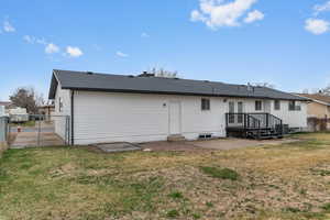 Back of house with a patio area, a shingled roof, and a gate