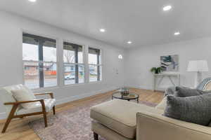 Living room featuring light wood finished floors and recessed lighting