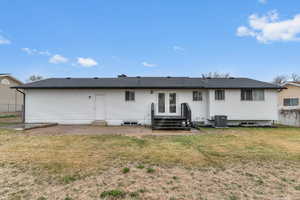 Back of house with entry steps and a patio
