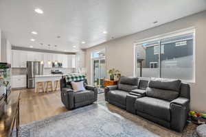 Living area featuring light wood-type flooring and recessed lighting