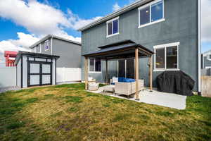 Rear view of property with a fenced backyard, outdoor furniture, a storage shed, and stucco siding