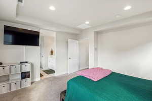 Bedroom with light carpet, recessed lighting, and ensuite bathroom