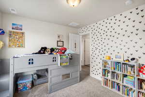 Bedroom featuring light carpet and wallpapered walls