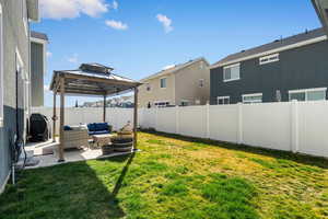 Fenced backyard featuring an outdoor living space, a patio, and a gazebo