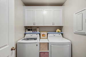 Laundry area with independent washer and dryer and cabinet space