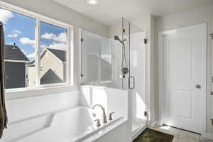 Bathroom with a shower stall and a garden tub