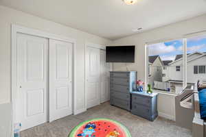 Recreation room with light colored carpet and baseboards