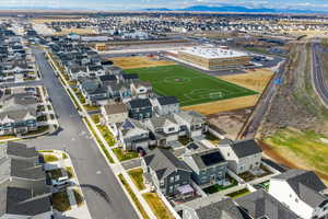Aerial view of property and surrounding area featuring nearby suburban area and mountains